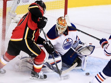 Calgary Flames'    Dougie Hamilton fights for the puck in front of Edmonton Oilers goaltender Cam Talbot this first period break away at the Scotiabank Saddledome on Saturday October 17, 2015.