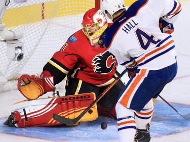 The Edmonton Oilers' Taylor Hall scrambles for the loose puck in front of Calgary Flames goaltender Jonas Hiller during the third period of NHL action at the Scotiabank Saddledome Saturday October 17, 2015.