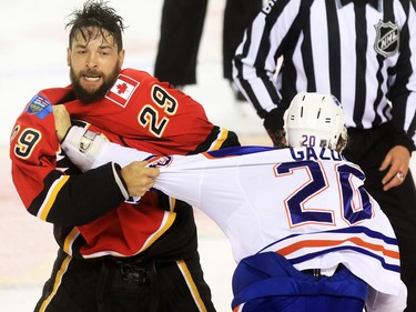 The Edmonton Oilers' Luke Gazdic and Calgary Flames defenceman Deryk Engelland fight during the first period of NHL action at the Scotiabank Saddledome Saturday October 17, 2015.
