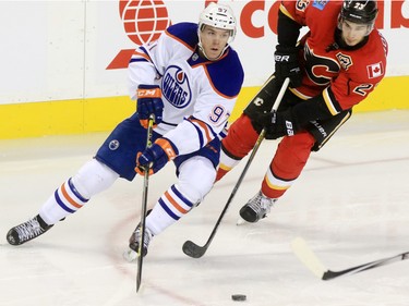 The Edmonton Oilers' Conner McDavid and Calgary Flames forward Sean Monahan chase the puck during the second period of NHL action at the Scotiabank Saddledome Saturday October 17, 2015.