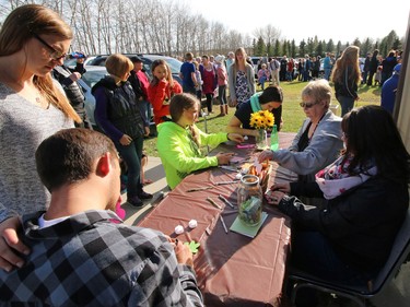 Supporters sign notes of condolences at the Withrow Gospel Mission for prior to a balloon release in memory of the three Bott sisters; Catie, 13, Dara, 11, and Jana, 11,  who died in a tragic farm accident earlier this week.