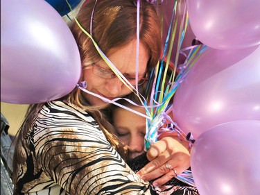 Bonita Bott gets a hug of support from a young girl at the Withrow Gospel Mission before a balloon release Sunday in memory of her three daughters: Catie, 13, Dara, 11, and Jana, 11, who died in a farm accident earlier this week.