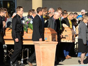 The three caskets of the Bott sisters; Catie, Jana and Dara are moved to hearses outside of the CrossRoads Church in Red Deer following their funeral on Fridya, Oct. 23, 2015.