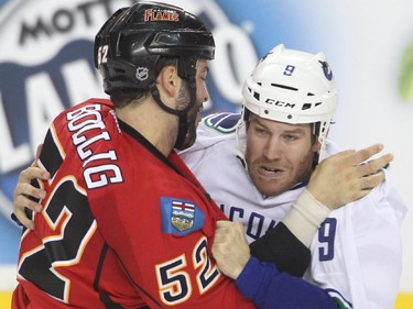 Brandon Bollig ties up Brandon Prust of he Vancouver Canucks Wednesday October 7, 2015 at the Saddledome.