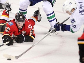 Calgary Flames assistant captain Sean Monahan sprawls but can't stop Vancouver's Bo Horvat from reaching a loose puck first. The Flames were a step behind the Canucks for most of Wednesday's home opener.