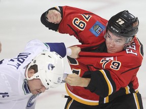 The season opens with a bang as Micheal Ferland of the Calgary Flames squares off with Derek Dorsett of the Vancouver Canucks in the opening seconds of the first period of the season opener Wednesday October 7, 2015 at the Saddledome.