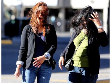 A gust of wind blows Edlyn Estrella's, left, and Elma Valvag's hair as they walk to church in downtown Calgary on October 11, 2015.