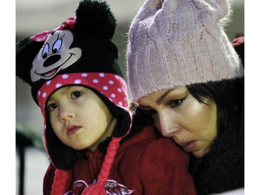 Jaci Cachene holds onto a young family member at a candle light vigil was for her sister Christa Cachene, on October 25, 2015 at Olympic Plaza. Christa was found beaten to death after a party at her house in Ranchlands.