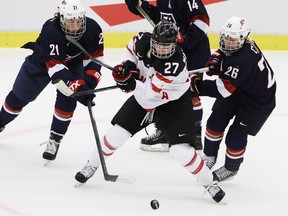 Canada's Tara Watchorn, center, fights for the puck with Hilary Knight, left, Brianna Decker, top, and Kendall Coyne during the Women's  Hockey World Championship group A match between the USA and Canada, at Malmo Isstadion, in Malmo, southern Sweden, Saturday,  March 28, 2015.