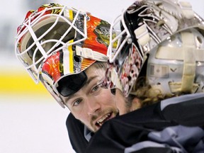 Joni Ortio talks with fellow Flames goalie Karri Ramo during practice in September. He's now in the minors after clearing waivers, leaving Ramo and Jonas Hiller tending the Flames' crease.