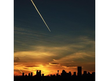 A jet heads west as the sun sets in Calgary on Monday October 5, 2015.