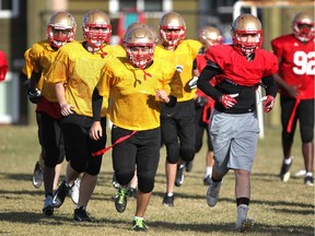 Colleen De Neve/ Calgary Herald CALGARY, AB -- OCTOBER 21, 2015 -- Members of the Lester B. Pearson Patriots ran into a team talk as they worked through drills during practice on October 21, 2015. The school's football program has returned to the turf this year after not running the past 10 of years. (Colleen De Neve/Calgary Herald) (For Sports story by Jeff MacKinnon) 00069475A SLUG: 1022-Lester B Pearson Football