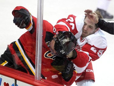 Calgary Flames centre Jiri Hudler was run into the boards as he and Detroit Red Wings centre Landon Ferraro scrapped during first period NHL action at the Scotiabank Saddledome on October 23, 2015. The Flames were looking to break their home game losing streak.