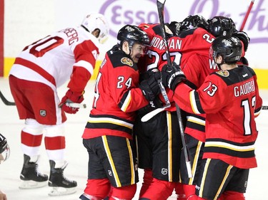 Members of the Calgary Flames, from left, centre Jiri Hudler, centre Sean Monahan, left winger Johnny Gaudreau, defenceman Dennis Wideman, defenceman Mark Giordano and centre Joe Colborne, obscured, celebrated after Colborne scored the tie goal against the Detroit Red Wings during third period NHL action at the Scotiabank Saddledome on October 23, 2015. The Flames broke their home game losing streak with the 3-2 overtime win over Detroit.
