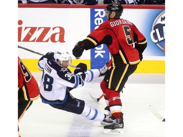 Calgary Flames defenceman Mark Giordano sent Winnipeg Jets left winger Nic Petan crashing to the ice during second period NHL action at the Scotiabank Saddledome on October 3, 2015.