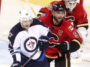 Calgary Flames defenceman Mark Giordano battles Winnipeg Jets centre Bryan Little during Saturday's pre-season game at the Scotiabank Saddledome.