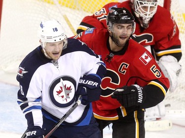 Calgary Flames defenceman Mark Giordano battles Winnipeg Jets centre Bryan Little during Saturday's pre-season game at the Scotiabank Saddledome.