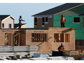 Construction workers at a single-family home in a new southeast Calgary community.