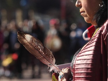 Christine Johnston holds a feather as she prays during the Sisters In Spirit ceremony for missing and murdered aboriginal women Monday October 5, 2015 in Eau Claire. A  Tahltan band member she personally knows half a dozen women who have either been killed or who are missing from her native Fort St John, BC area. Dozens walkeded from City Hall to Eau Claire in the 11th annual march and ceremony.