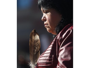 Christine Johnston holds a feather as she prays during the Sisters In Spirit ceremony for missing and murdered aboriginal women Monday October 5, 2015 in Eau Claire. A  Tahltan band member she personally knows half a dozen women who have either been killed or who are missing from her native Fort St John, BC area. Dozens walked from City Hall to Eau Claire in the 11th annual march and ceremony.