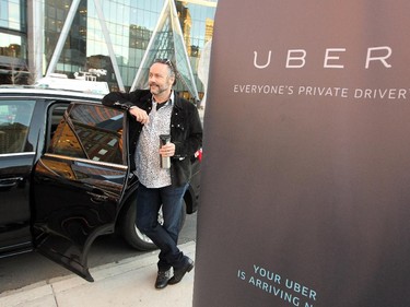 Calgary businessman and philanthropist Brett Wilson climbed out of the back of an Uber vehicle after catching a ride downtown as rider zero during the morning rush hour on October 15, 2015.