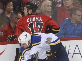 Calgary Flames forward Lance Bouma takes a hit from St. Louis Blues' Kyle Brodziak during Tuesday's game. He later broke his fibula and had successful surgery on Wednesday. When he might be back remains up in the air, but the initial timeline was three months.