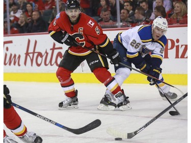 Calgary Flames captain Mark Giordano tries to stop a pass from St. Louis Blues Paul Stastny during game action at the Saddledome in Calgary, on October 13, 2015.