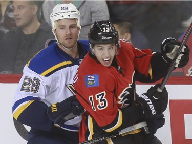 Calgary Flames Johnny Gaudreau gets tangled up with St. Louis Blues Kyle Brodziak during game action at the Saddledome in Calgary, on October 13, 2015.