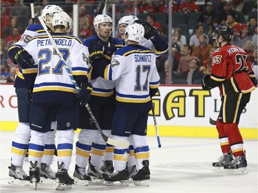 The St. Louis Blues celebrate a goal as Sean Monahan skates back to the bench during game action at the Saddledome in Calgary, on October 13, 2015.