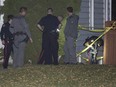 Police search for evidence and tape off several areas after a shooting on Hendon Drive N.W. in Calgary, on October 15, 2015.