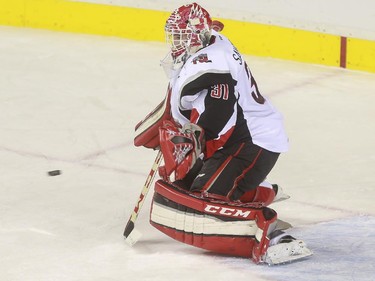 Moose Jaw Warriors' Zach Sawchenko makes a big save during game action against the Calgary Hitmen at the Saddledome in Calgary, on October 15, 2015.