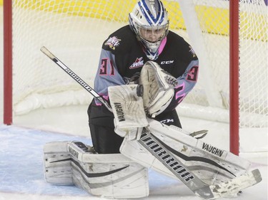 Calgary Hitmen's Lasse Petersen watches the puck into his glove during game action against the Moose Jaw Warriors at the Saddledome in Calgary, on October 15, 2015.