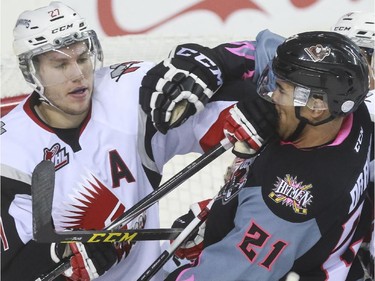 Calgary Hitmen's Terrell Draude takes a poke to the face from Moose Jaw Warriors' Tanner Faith during game action at the Saddledome in Calgary, on October 15, 2015.