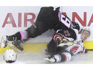 The Calgary Hitmen's Radel Fazleev has falls awkwardly after a check from Moose Jaw Warriors' Noah Gregor during game action at the Saddledome in Calgary, on October 15, 2015. -