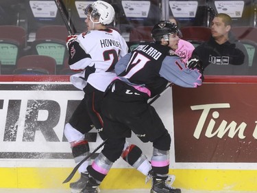 Calgary Hitmen's Jordy Stallard crushes Moose Jaw Warriors' Brett Howden into the boards during game action at the Saddledome in Calgary, on October 15, 2015.