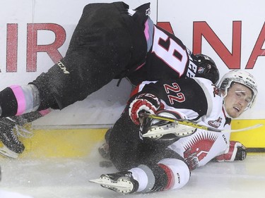 Calgary Hitmen's Radel Fazleev has falls awkwardly after a check from Moose Jaw Warriors' Noah Gregor during game action at the Saddledome in Calgary, on October 15, 2015.