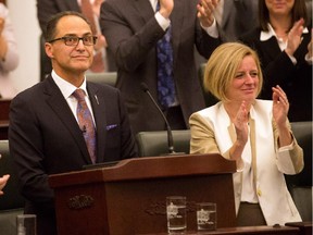 Alberta Finance Minister Joe Ceci, left, receives a round of applause after delivering the 2015 provincial budget at the legislature in Edmonton on Tuesday, Oct. 27, 2015.
