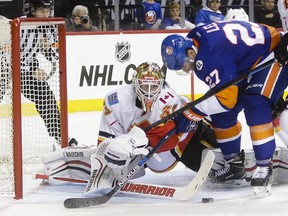 Calgary Flames goalie Joni Ortio stops a shot on the goal by New York Islanders' Anders Lee during the second period on Monday night.