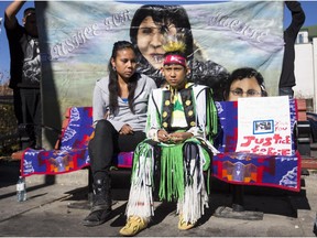 Jackie Crazybull's daughter, Tamara, left, and son Clifford, sit in the last spot their mother sat before she was murdered eight years ago in Calgary. Dozens of friends and family members gathered for the annual march down 17th Avenue S.W. in her memory on October 17, 2015.