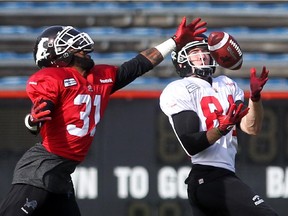 Calgary Stampeders defensive back Brandon McDonald, left, tries to intercept a pass to slotback Greg Wilson during practice at McMahon Stadium on Wednesday.