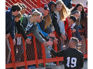 Students from Madeleine d'Houet school high five with Calgary Stampeders quarterback Bo Levi Mitchell following team practise on Tuesday Oct. 27, 2015.