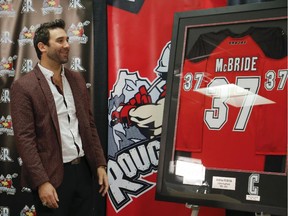 Andrew McBride admires a framed jersey — his last game-worn silks he donned — presented to him by the Calgary Roughnecks at his retirement announcement on Friday.