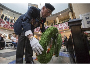 Joey Bleviss, chief administrative office, Calgary Poppy Fund, Veterans Food Bank, places the last wreath in remembrance of fallen comrades at the poppy launch parade in Calgary, on October 31, 2015.