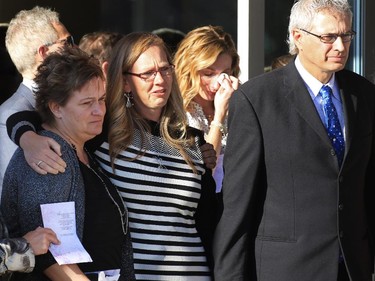 Comforted by family, Bonita Bott, with glasses and her husband Roger Bott watch as the three caskets of their daughters; Catie, Jana and Dara are moved into hearses outside of the CrossRoads Church in Red Deer following their funeral on Friday October 23, 2015. The three girls died in a farm accident near Withrow AB on Oct. 14.