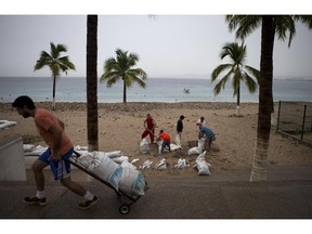 Residents prepare for the arrival of Hurricane Patricia filling sand bags to protect beachfront businesses, in Puerto Vallarta, Mexico, Friday, Oct. 23, 2015. Patricia barreled toward southwestern Mexico Friday as a monster Category 5 storm, the strongest ever in the Western Hemisphere. Locals and tourists were either hunkering down or trying to make last-minute escapes ahead of what forecasters called a "potentially catastrophic landfall" later in the day.