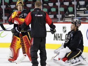 Calgary Flames goalie coach Jordan Sigalet, middle, with flames goalies Jonas Hiller, left and Karri Ramo, right during practice at the Scotiabank Saddledome in Calgary on September 23, 2015.