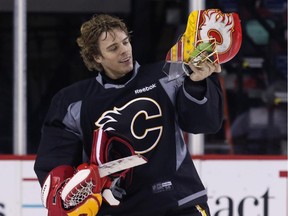 Calgary Flames goalie Jonas Hiller checks his mask during practice at the Scotiabank Saddledome on Thursday. He will get the start on Saturday in Vancouver.