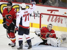 Calgary Flames defenceman Dougie Hamilton, left, and goalie Karri Ramo reacted as Washington Capitals right winger T.J. Oshie celebrates scoring the Capitals' fourth goal of the game during second period on Tuesday. Hamilton was tossed aside by a charging Oshie on the play, who scored to chase Ramo from the crease in a 6-2 Caps triumph.