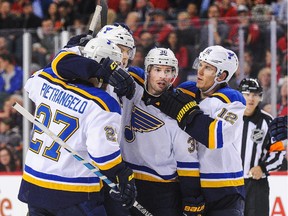 Members of the St. Louis Blues congratulate Colton Parayko (No. 55, second from left) on one of his two goals against the Calgary Flames on Tuesday night.