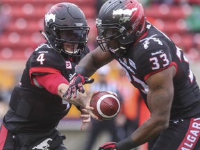 Calgary Stampeders backup quarterback Drew Tate takes a turn and makes a hand off to Jerome Messam during game action against the Roughriders at McMahon Stadium in Calgary, on October 31, 2015.